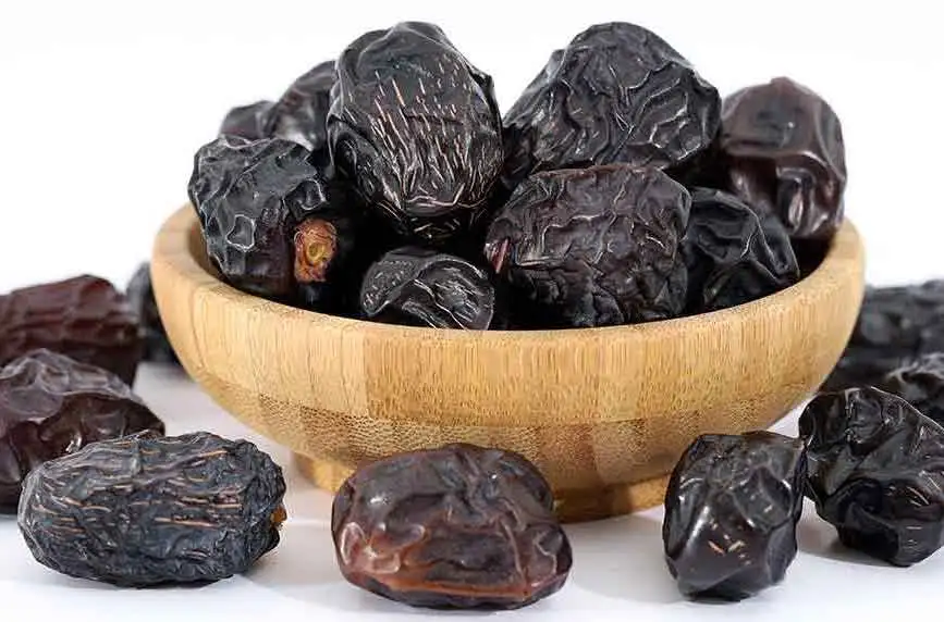 Kurma Ajwa berwarna kehitaman di dalam sebuah mangkok kayu