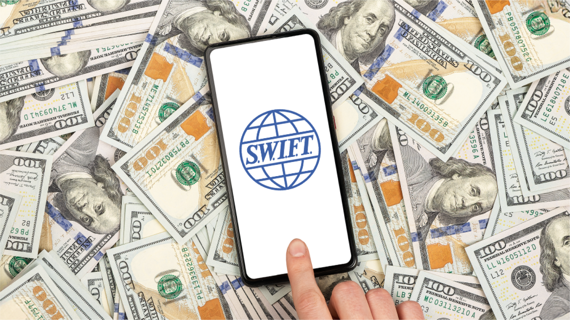 Ilustrasi smartphone di atas tumpukan uang dolar AS, dengan logo SWIFT muncul dilayar dan sebuah jari telunjuk menyentuh layarnya, menggambarkan salah satu bentuk transaksi internasional.