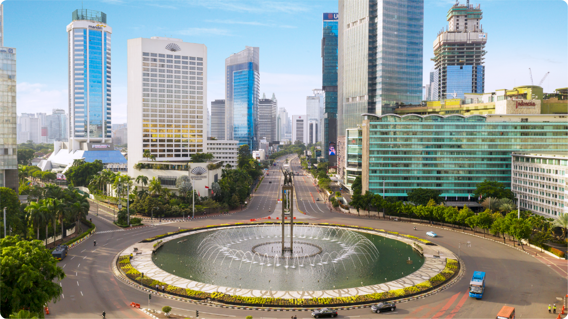高層ビル、道路、噴水のあるラウンドアバウトが見えるジャカルタ中心部の風景。インドネシアの都市生活を表しています。