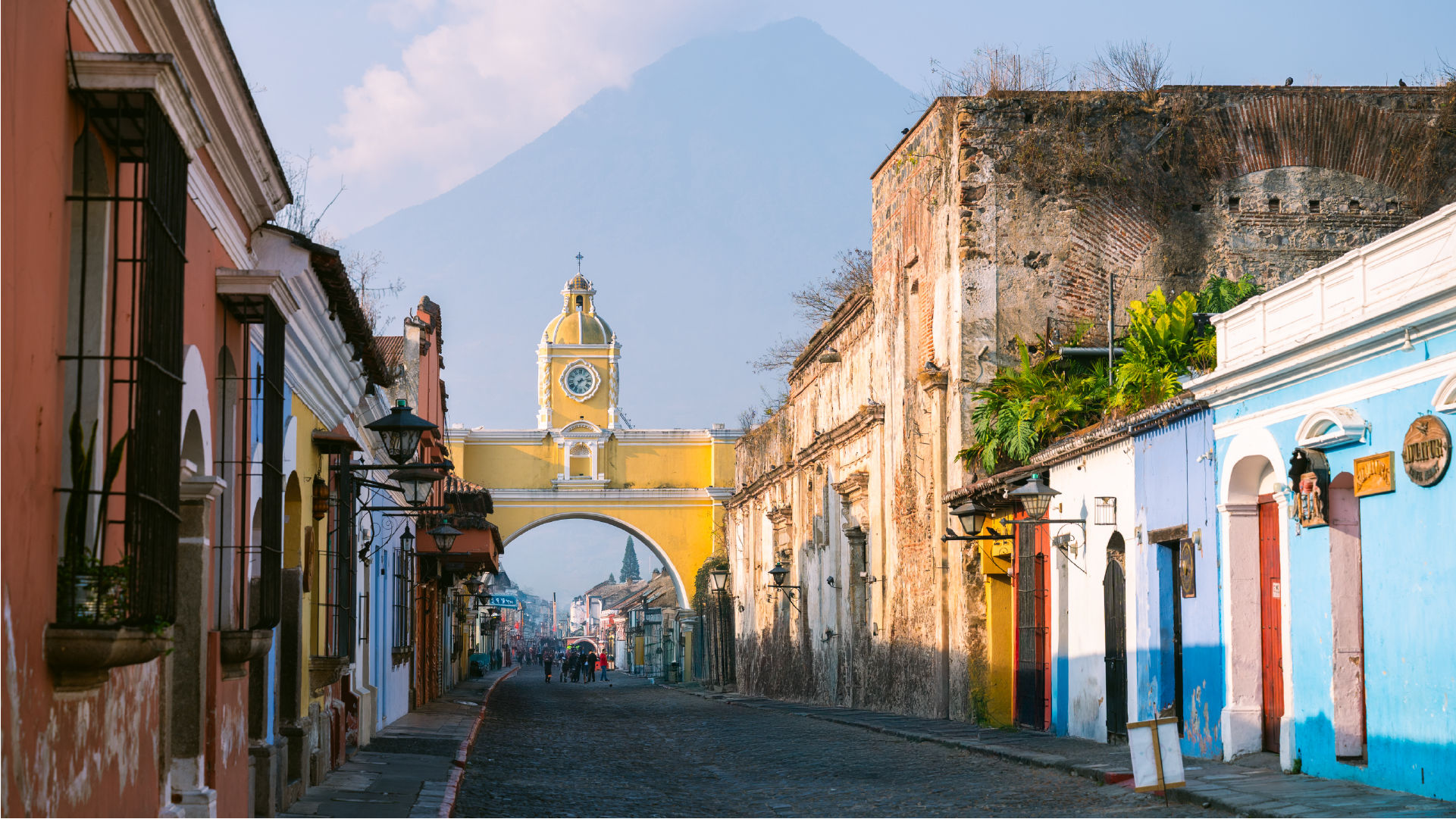 Jalan bersejarah di Guatemala dengan bangunan warna-warni sebagai ilustrasi negara yang bergantung pada remitansi.