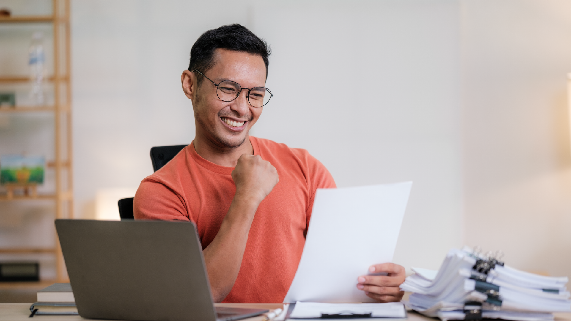 Pelaku usaha bersemangat membaca dokumen di depan laptop, menggambarkan proses pengecekan izin khusus dan persyaratan impor yang berhasil dilakukan.