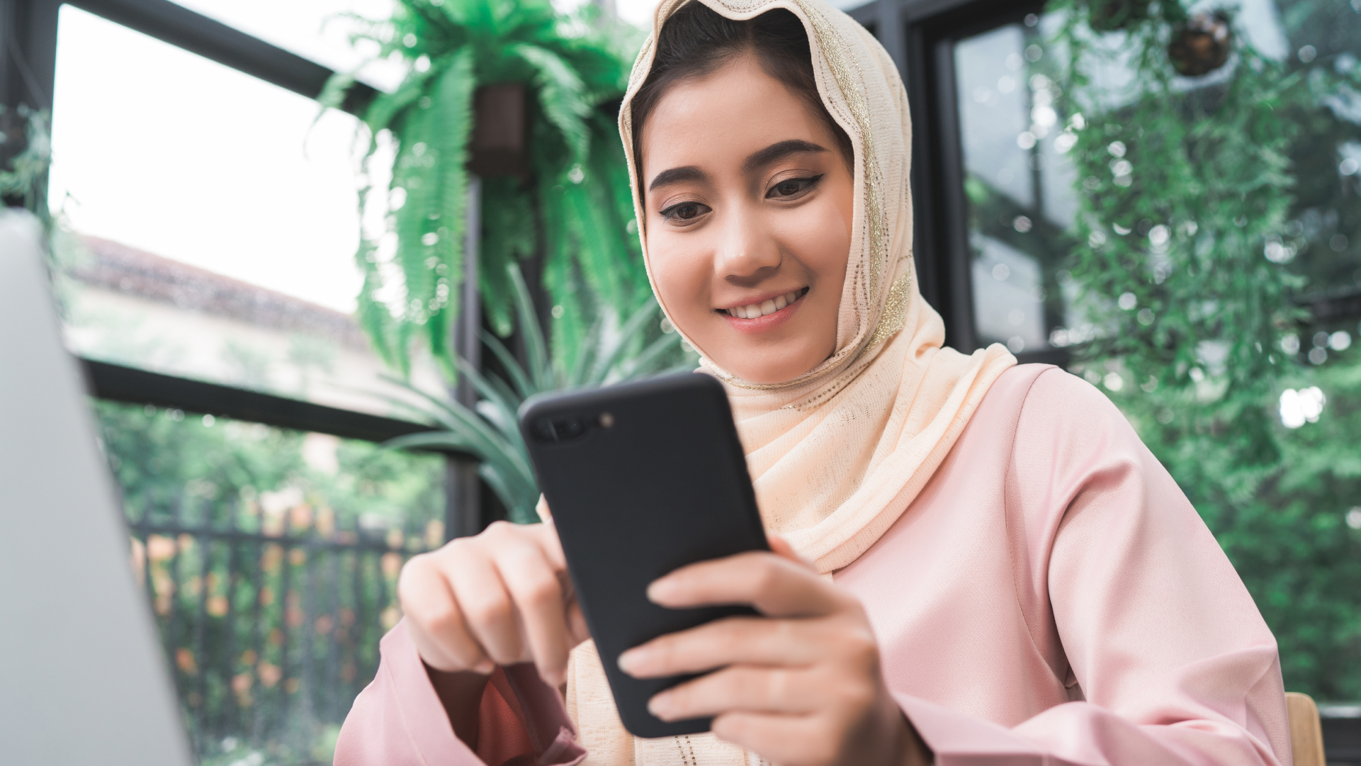 Pengguna membuka aplikasi di ponsel untuk mengirim uang dari Indonesia ke Malaysia secara online.