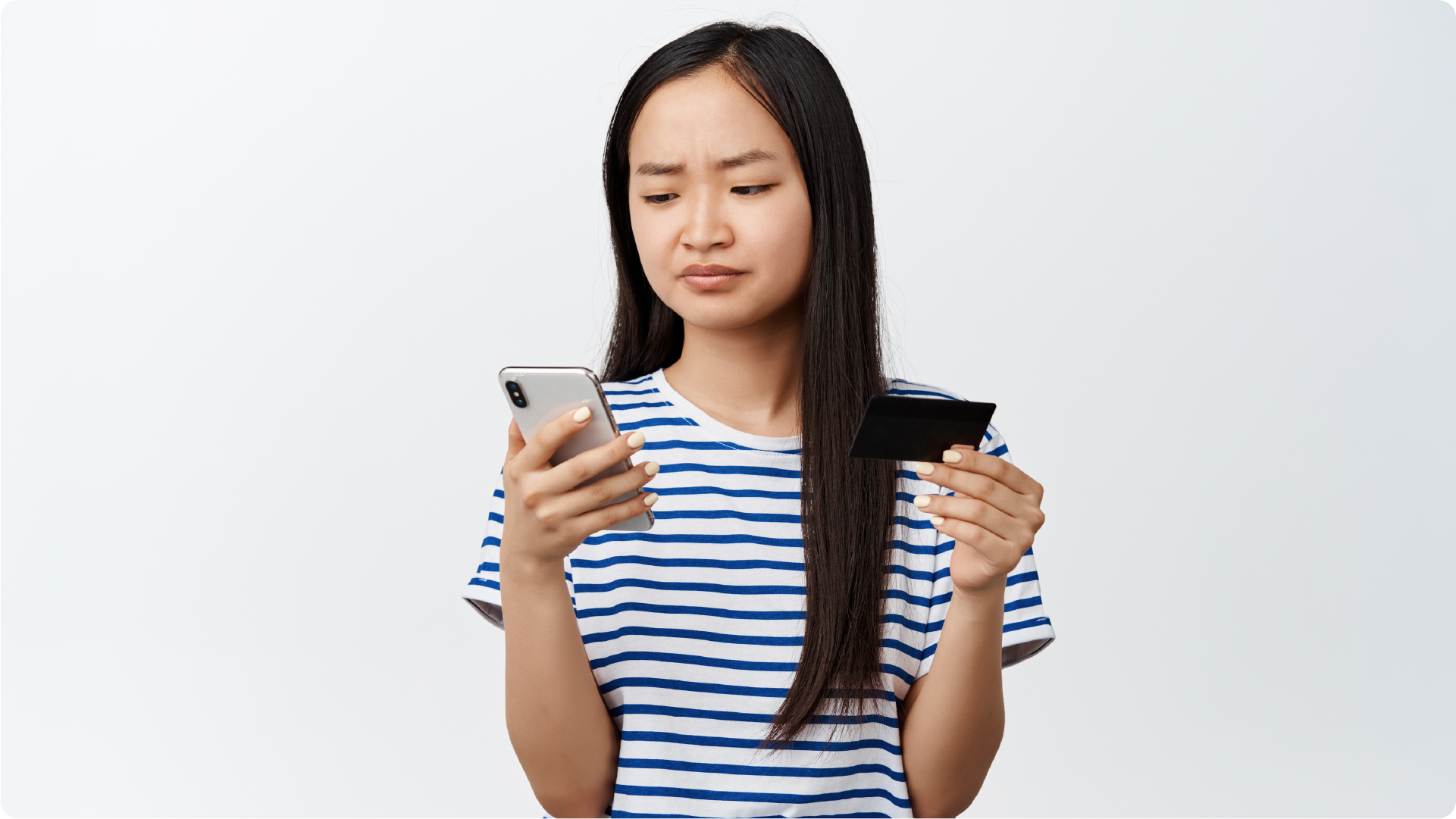 Perempuan terlihat bingung saat memeriksa kartu dan HP untuk transaksi online.