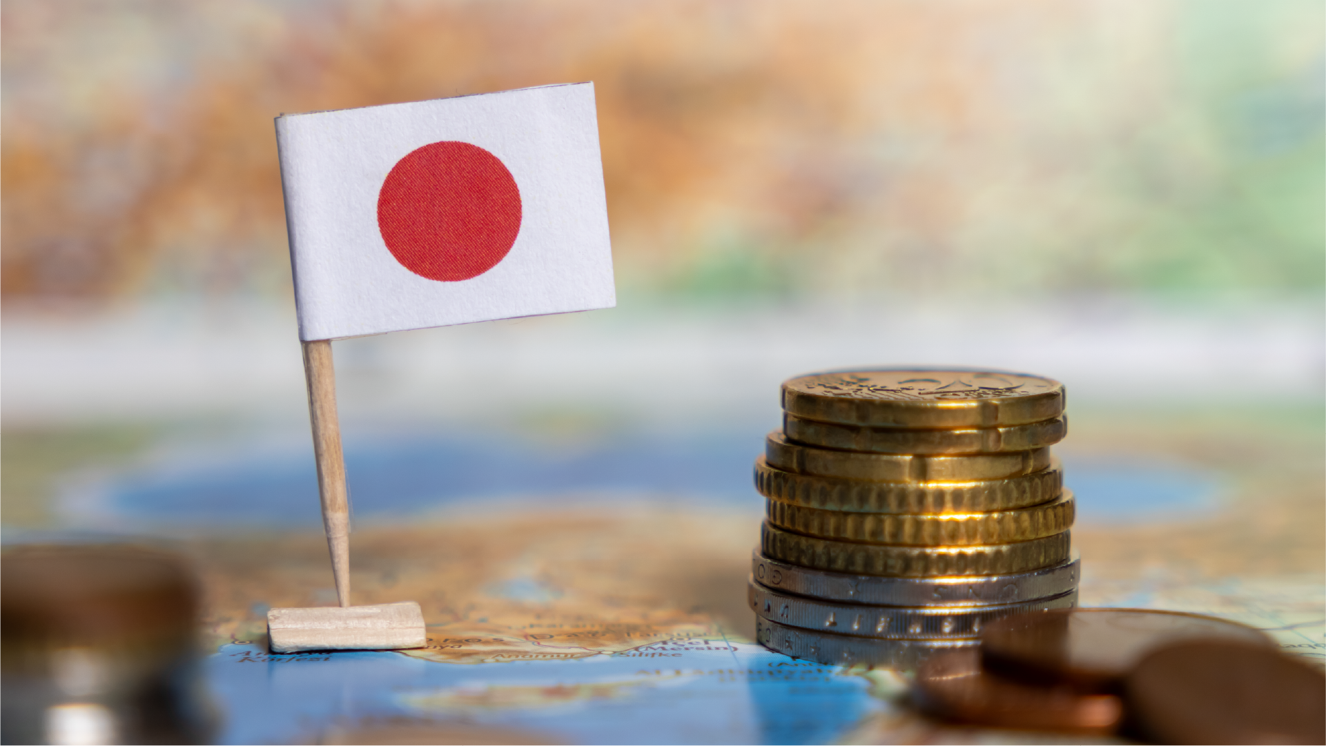 日本国旗と硬貨のイメージ。インドネシアから日本円で送金する際の為替レート確認を表現。