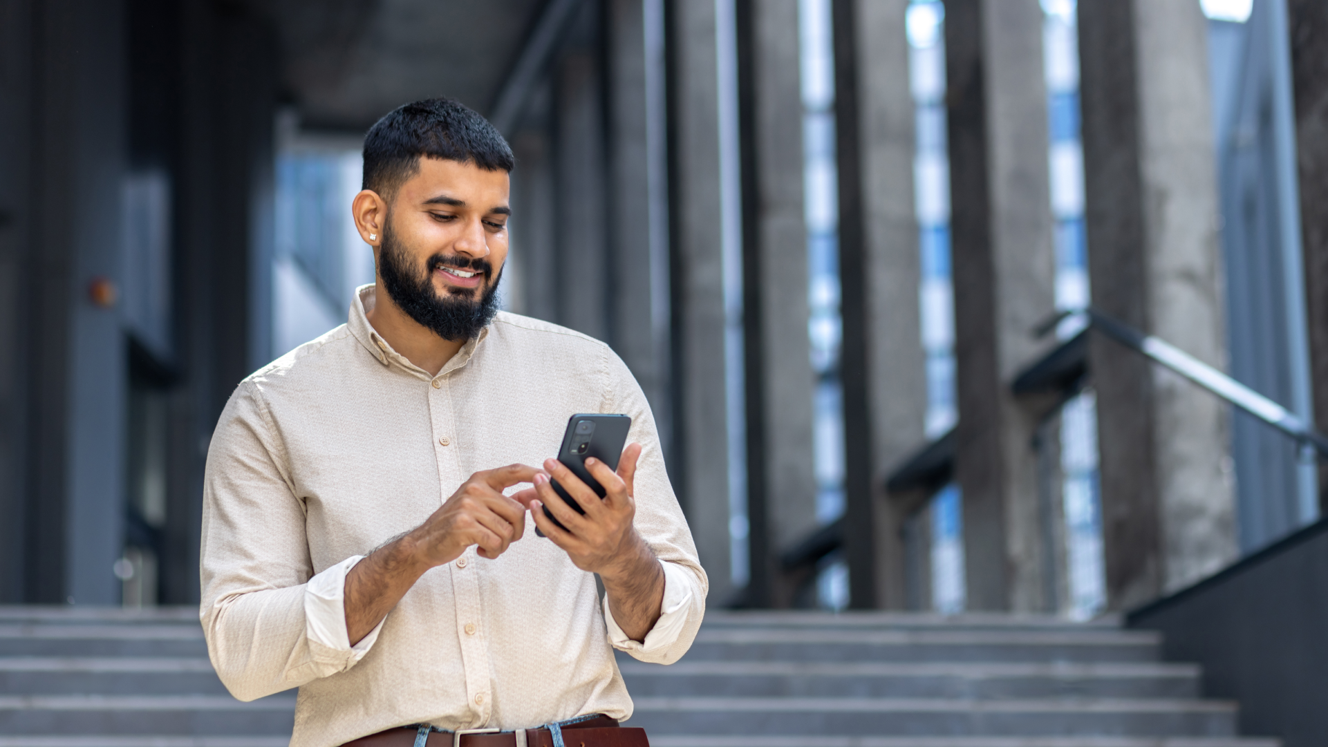 Pria menggunakan smartphone untuk transfer uang ke India secara online
