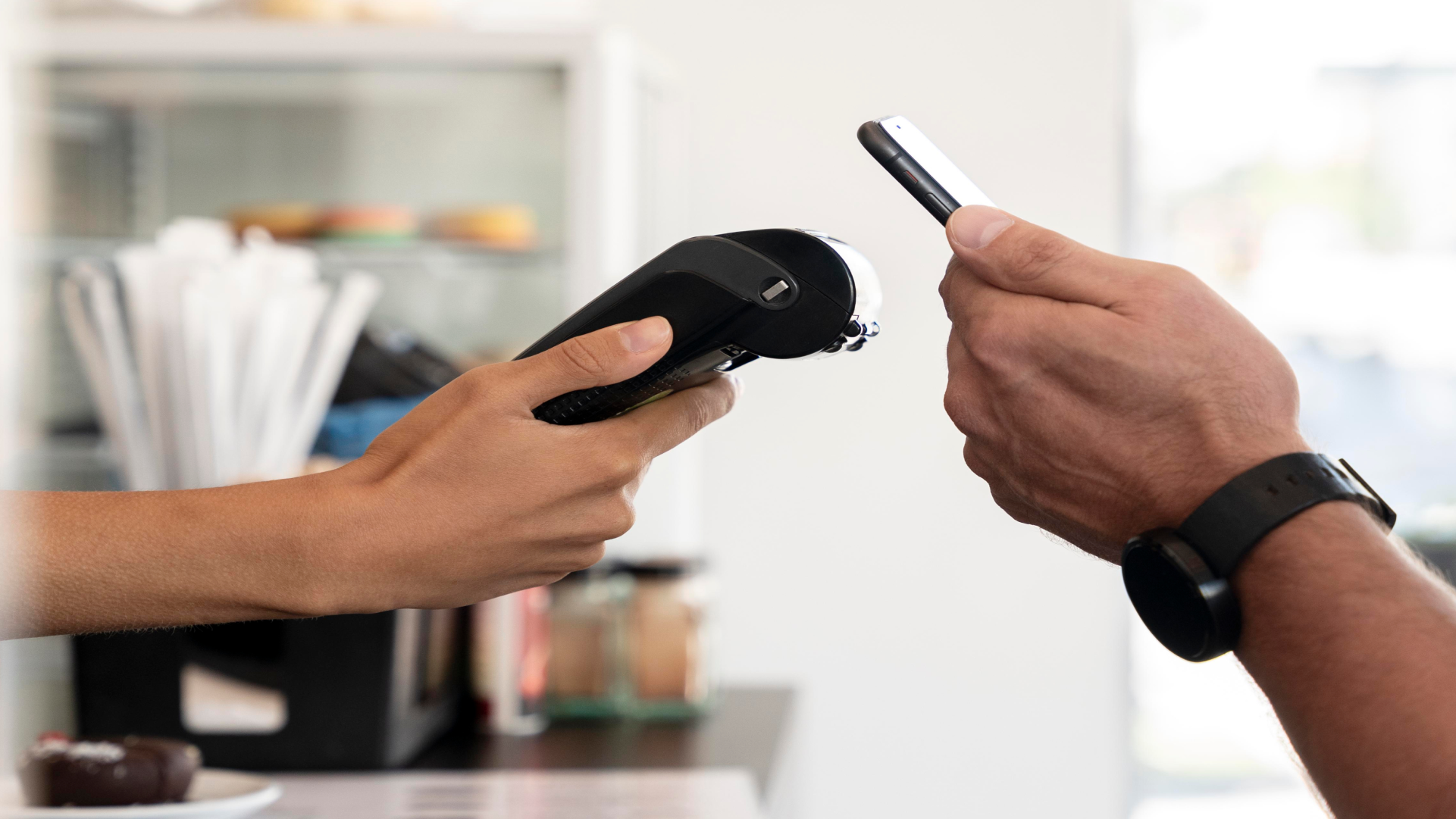 Ilustrasi pembayaran nontunai menggunakan ponsel dan mesin pembayaran elektronik di merchant