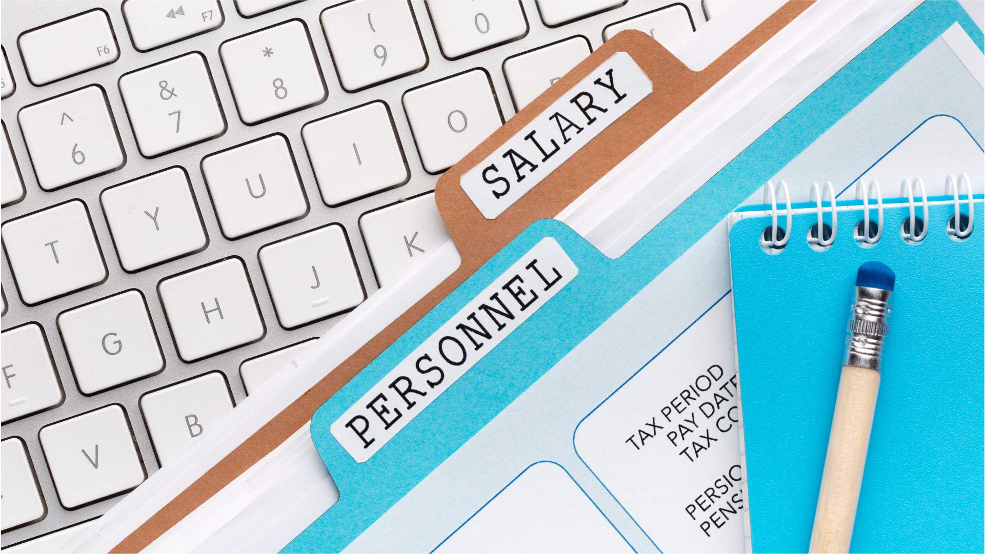 キーボードの上に置かれた「SALARY（給与）」と「PERSONNEL（人事）」のラベルが付いた書類ファイル
