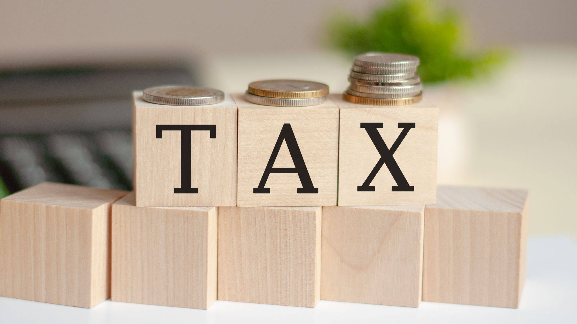 税金を表す「TAX」の文字とコイン。日本への海外送金に関する報告や税務をイメージした画像