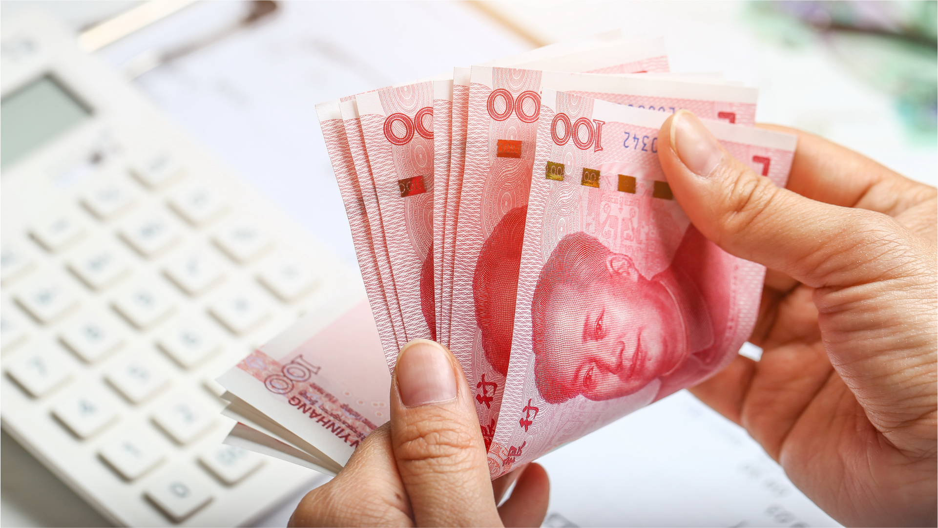 Tangan seseorang menghitung uang Yuan untuk pembayaran supplier di China