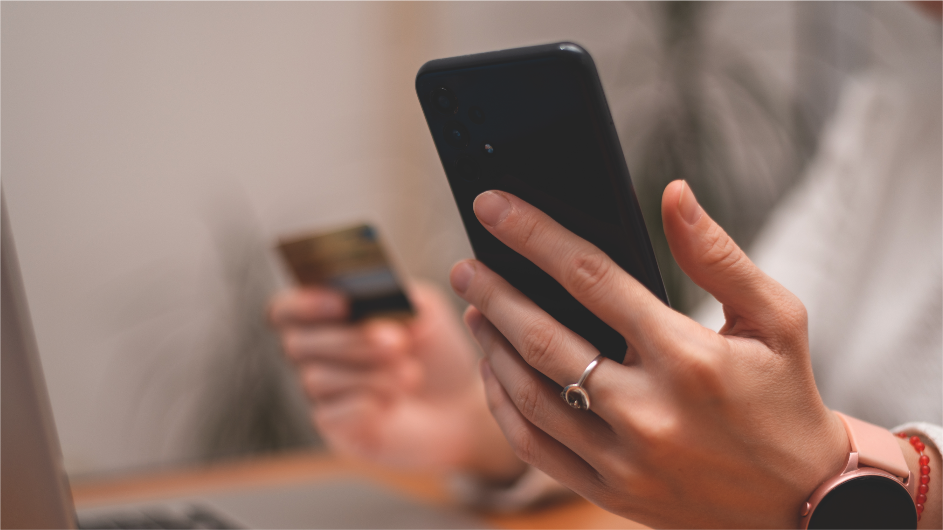 Seseorang melakukan pembayaran internasional melalui smartphone dan kartu bank