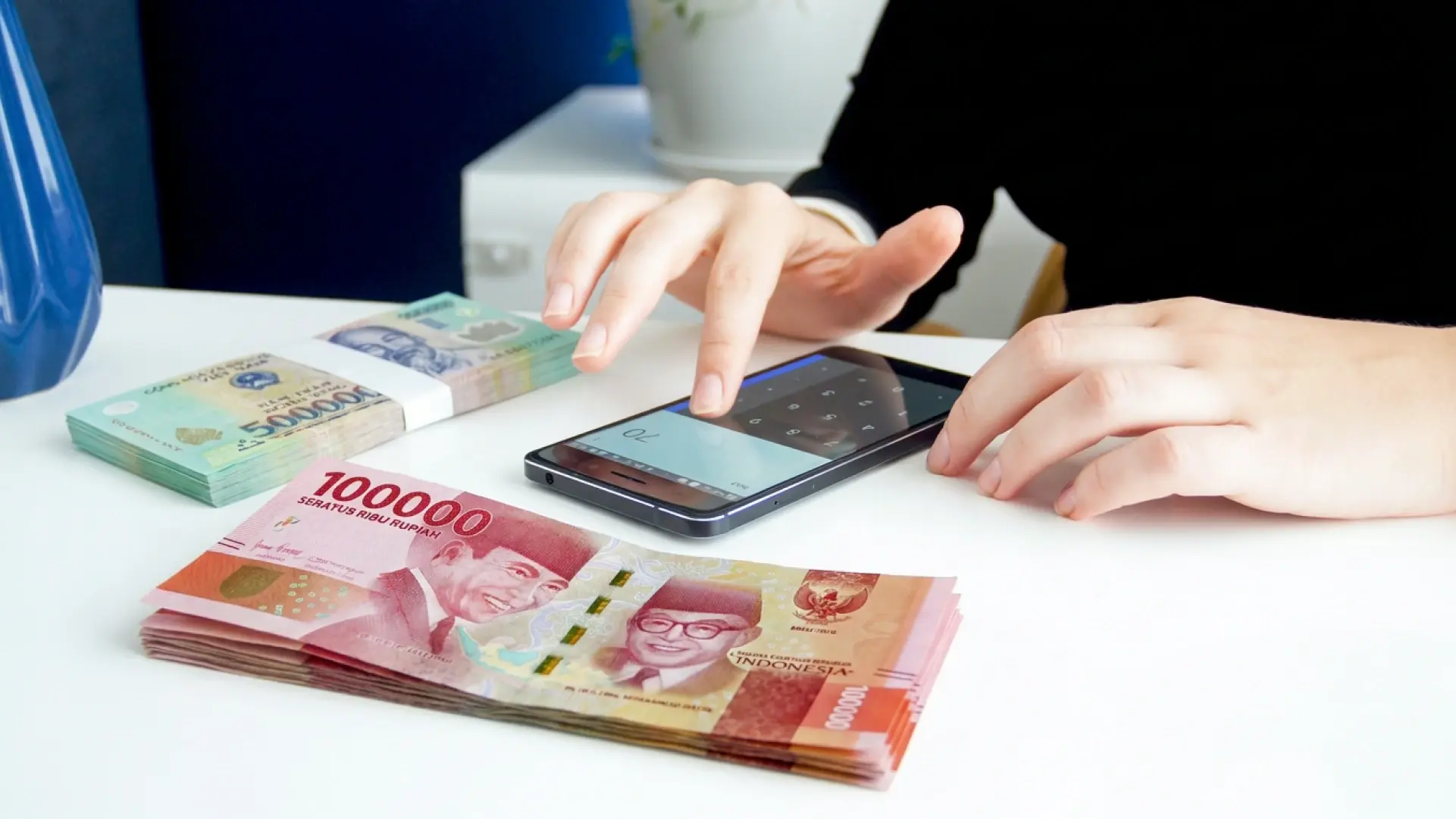 Người dùng tính toán số tiền chuyển bằng Rupiah trên điện thoại