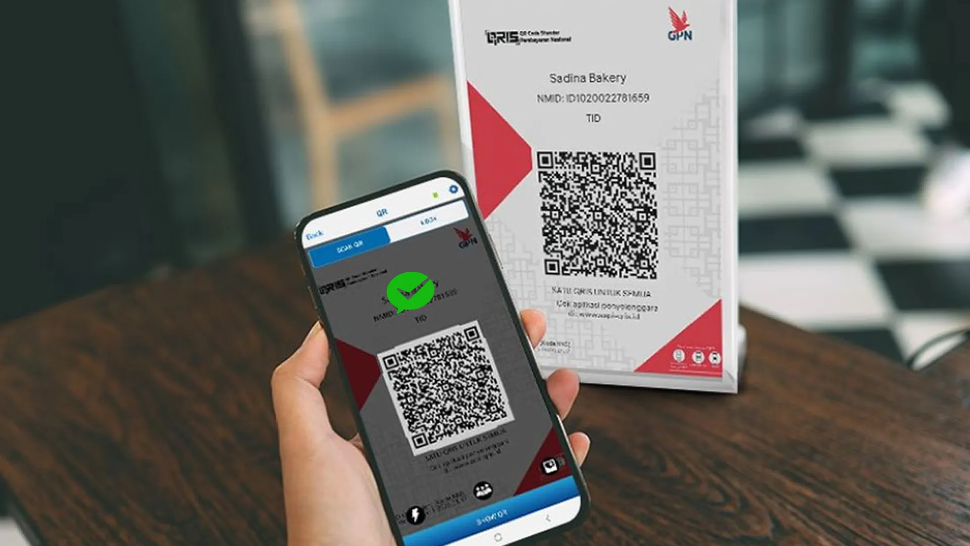 用户使用手机扫描印尼商家的 QRIS 收款码，手机屏幕上显示微信支付（WeChat Pay）标志。