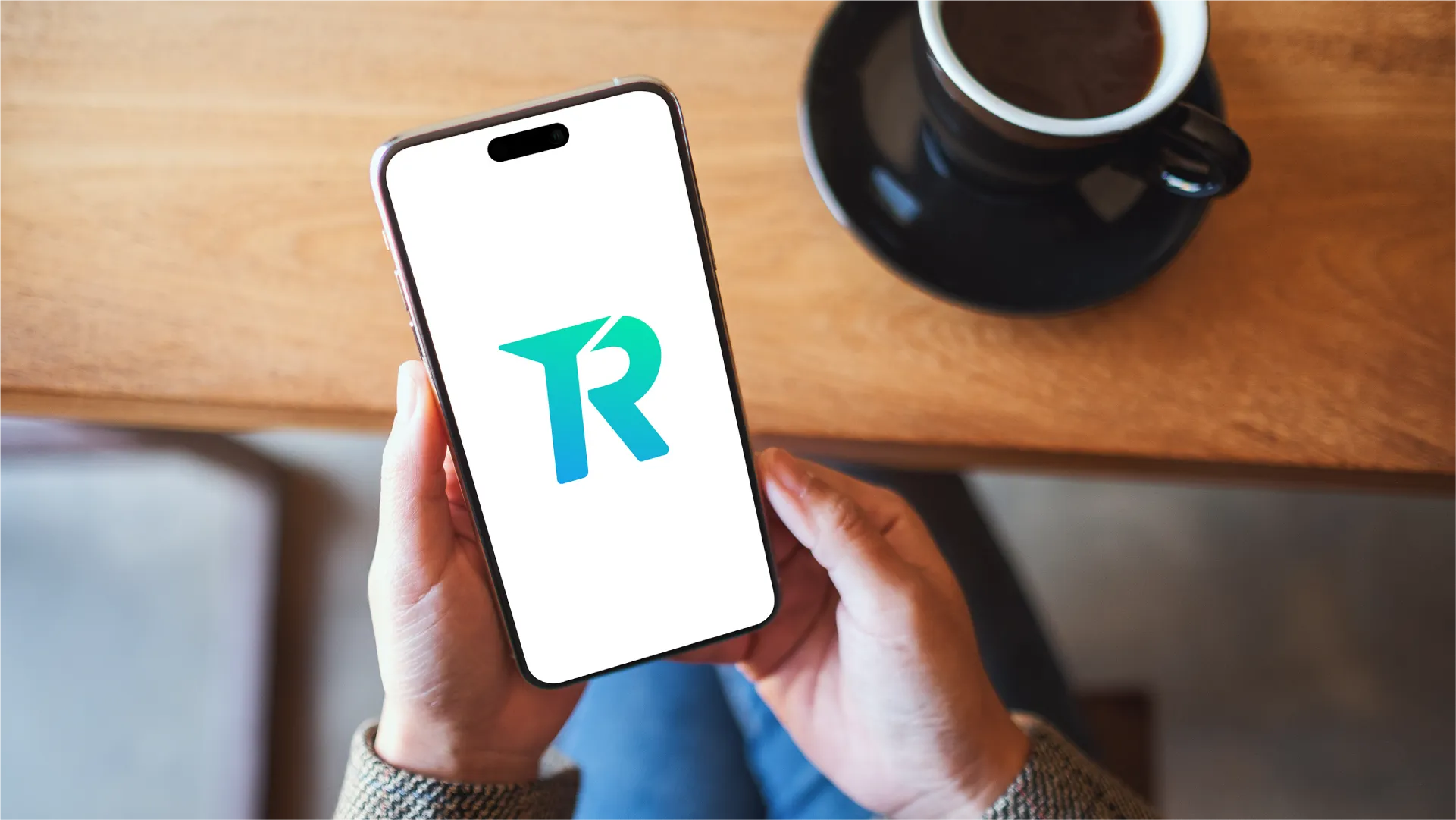 Seseorang menggunakan smartphone dengan logo Topremit di layar untuk melakukan transfer uang internasional.