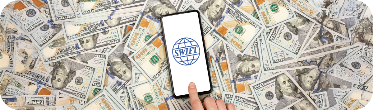 Sebuah smartphone dengan logo SWIFT di layar di atas tumpukan uang dolar AS yang melambangkan sistem pembayaran internasional.