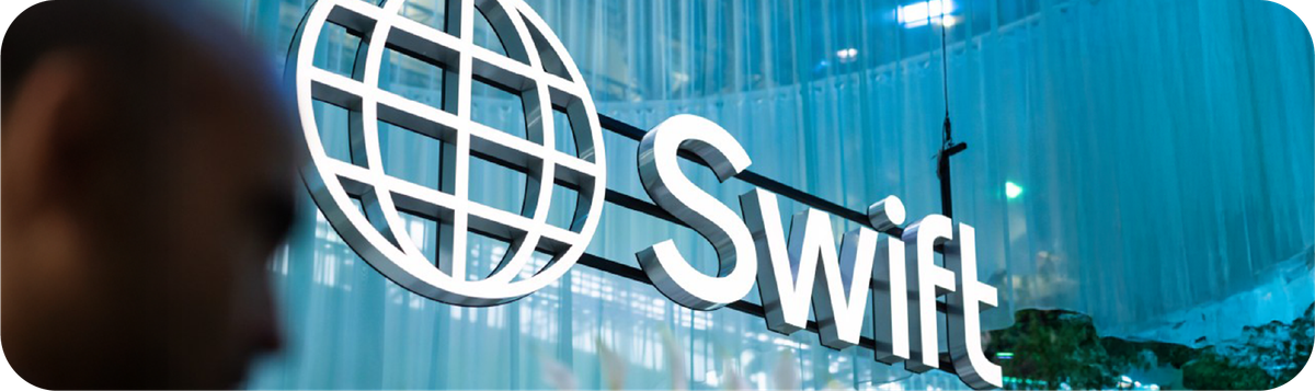 Logo SWIFT (Society for Worldwide Interbank Financial Telecommunication) di sebuah gedung perkantoran modern.