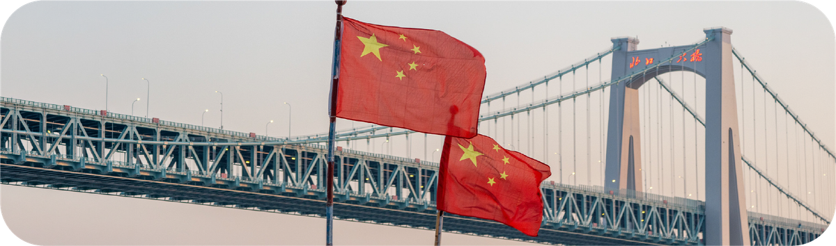 中国国旗在大桥前飘扬，象征从印度尼西亚汇款到中国的跨境交易场景。
