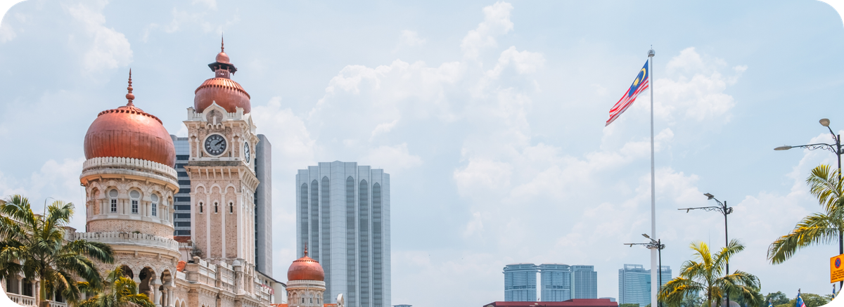 Pemandangan Kuala Lumpur dengan bendera Malaysia sebagai ilustrasi tujuan transfer uang ke Malaysia.