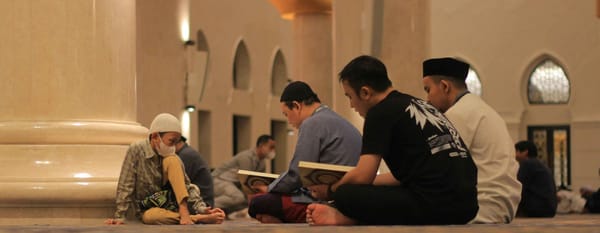 Suasana di dalam masjid yang berisi sejumlah jemaah sedang membaca Al-Quran. 