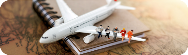 Miniatur pesawat di atas peta dunia yang menggambarkan mobilitas lintas negara bagi ekspatriat dan pekerja migran.