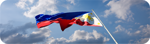 Bendera Filipina berkibar di langit sebagai ilustrasi negara tujuan transfer internasional.
