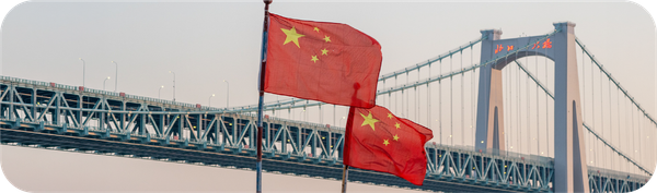 中国国旗在大桥前飘扬，象征从印度尼西亚汇款到中国的跨境交易场景。